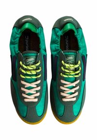Sneaker in tessuto verde e blu con lacci beige e accenti laterali viola. Presenta una suola testurizzata e un collare imbottito.