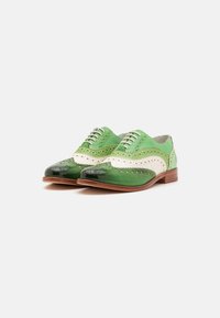 Scarpe in pelle verde con dettagli brogue. Presentano una punta lucida di un verde scuro e accenti bianco sporco. Chiusura con lacci e suola marrone medio.