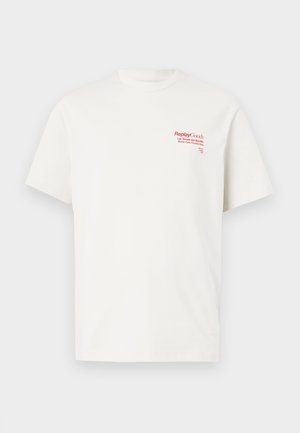 Biely bavlnený tričko s krátkymi rukávmi. Na ľavej strane hrude sa nachádza červený potlačený text vrátane "Replay Goods" a grafického loga.