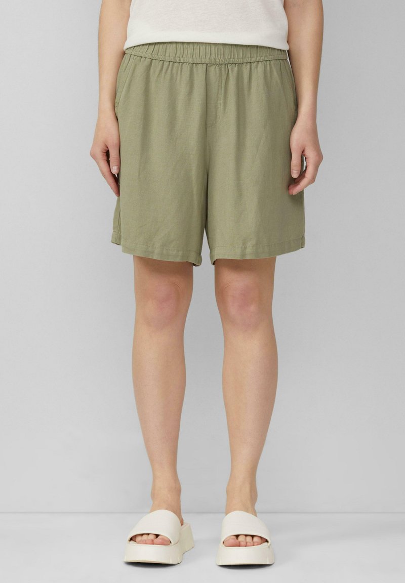 Oliwkowe szorty wykonane z lekkiego materiału, z elastycznym pasem i luźnym krojem, o gładkiej fakturze i bez widocznych wzorów.