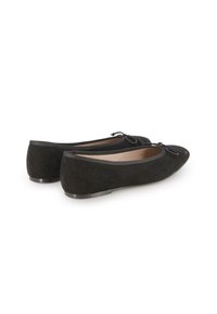 Zapatos planos de ante negros con punta redonda y un detalle de lazo en la parte delantera. Cuentan con una suela de goma negra y un diseño sencillo.