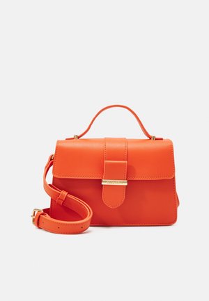 Sac à main en cuir orange vif avec une poignée supérieure, un rabat à boucle et une bandoulière réglable, posé sur un fond clair et uni.