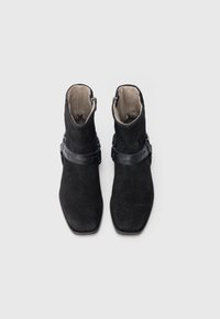 Černé semišové kotníkové boty s hladkým koženým páskem, čtvercovou špičkou a zapínáním na zip, s lehkou vnitřní podšívkou.
