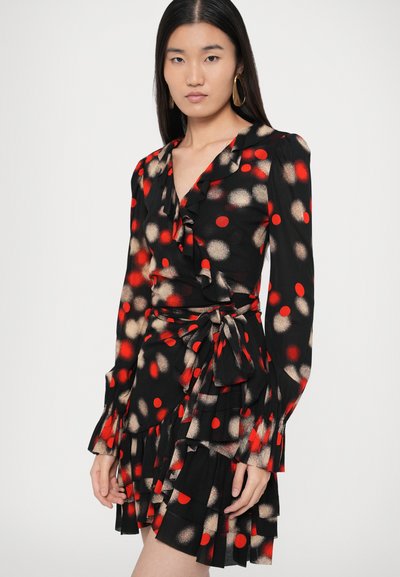 Μαύρο φόρεμα με κόκκινες και μπεζ πουά, λαιμόκοψη και μανίκια με βολάν, ζώνη στη μέση και πολυεπίπεδη φούστα με βολάν.