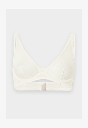 Soutien-gorge blanc à bonnets souples avec bretelles fines réglables, bonnets triangulaires et fermeture à agrafes sur le devant, sur un fond clair uni.