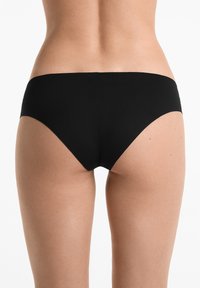 Fekete bikinialsó sima anyagból készült. Alacsony derékú fazonnal rendelkezik, minimális takarással és varrás nélküli derékpánttal.