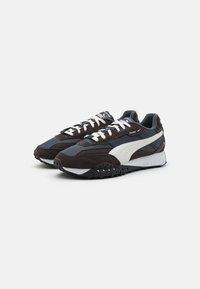 Scarpe da allenamento nere e grigie con tomaia in suede testurizzato, lacci bianchi e suola in gomma con motivo. Presentano un design a swoosh a contrasto.