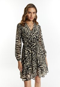 Rochie cu imprimeu animalier negru și bej, cu decolteu în V, mâneci lungi și fustă în straturi. Fabricată dintr-un material ușor și transparent, cu talie strânsă.