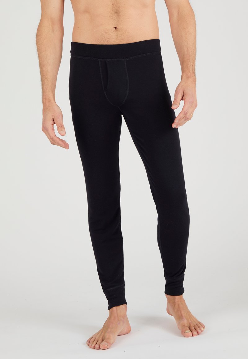 Leggings negros hechos de material elástico, diseño ajustado, con una cinturilla elástica y un bolsillo delantero, que cuentan con una textura suave y sin patrones.