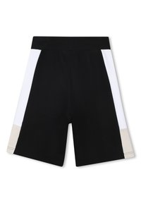 Shorts de sport noirs avec des panneaux latéraux blancs et beiges, en tissu doux, avec une taille élastique, coupés au niveau des genoux, et des détails de couture minimaux.