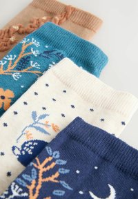 Neljät parit neulottuja sukkia: beige, jossa on tekstuuri, teal, jossa on puumotiivi, kerma kukilla pisteittäin, ja tummansininen, jossa on kuu- ja lehmussuunnitelmat.