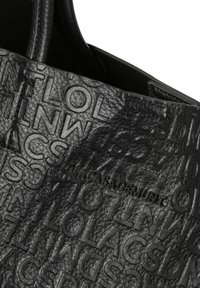 Bolso tote de cuero negro con diseño de logotipo en relieve, que presenta una textura suave y dos asas. El interior es sin forro y simple.