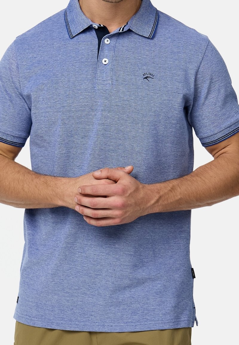 Polo à manches courtes en tissu texturé bleu clair, avec un col, une patte de boutonnage et des accents rayés bleu marine sur les manches.