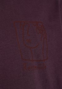 Lilla bomulds T-shirt med en brun kontur af et ansigt med bølget hår og teksten "Resteröds" nedenunder i matchende brun.