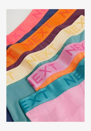 Colorful waistband briefs arranged in layers, featuring a range of colors including pink, orange, green, and navy with textured "NEXT" branding.