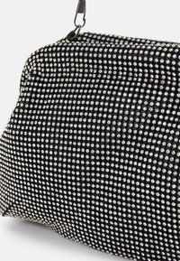 Malá černá večerní taška pokryta rovnoměrně rozmístěnými stříbrnými třpytkami, se železným zapínáním a řetízkem na nošení.