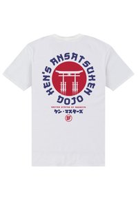 Bílý bavlněný tričko s kruhovou červenou grafikou, na které je torii brána, text modré a červené barvy a japonské znaky pod designem.