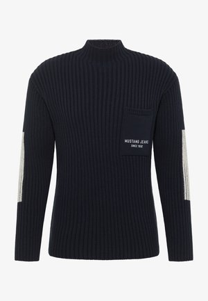 Marineblauwe geribbelde trui met hoge nek en lange mouwen. Voorzien van een borstzak met de tekst "MUSTANG JEANS SINCE 1932" erop gedrukt. Lichtere grijze accenten op de mouwen.