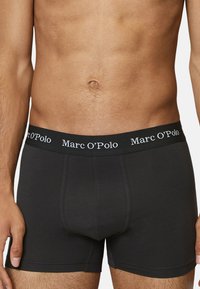 Boxer neri in cotone con una vestibilità aderente, dotati di un ampio elastico in vita con la scritta "Marc O'Polo" in lettere bianche.