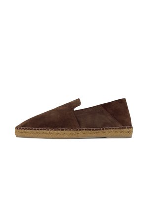 Alpargata marrón de ante tipo slip-on con suela trenzada de yute y un pequeño panel lateral elástico, mostrada sobre fondo blanco.
