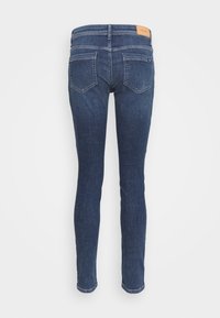 Mörkblå tajta jeans med midja i normalhöjd, femficksdesign och läderpatch på bakre midjebandet. Slät denimtextur.