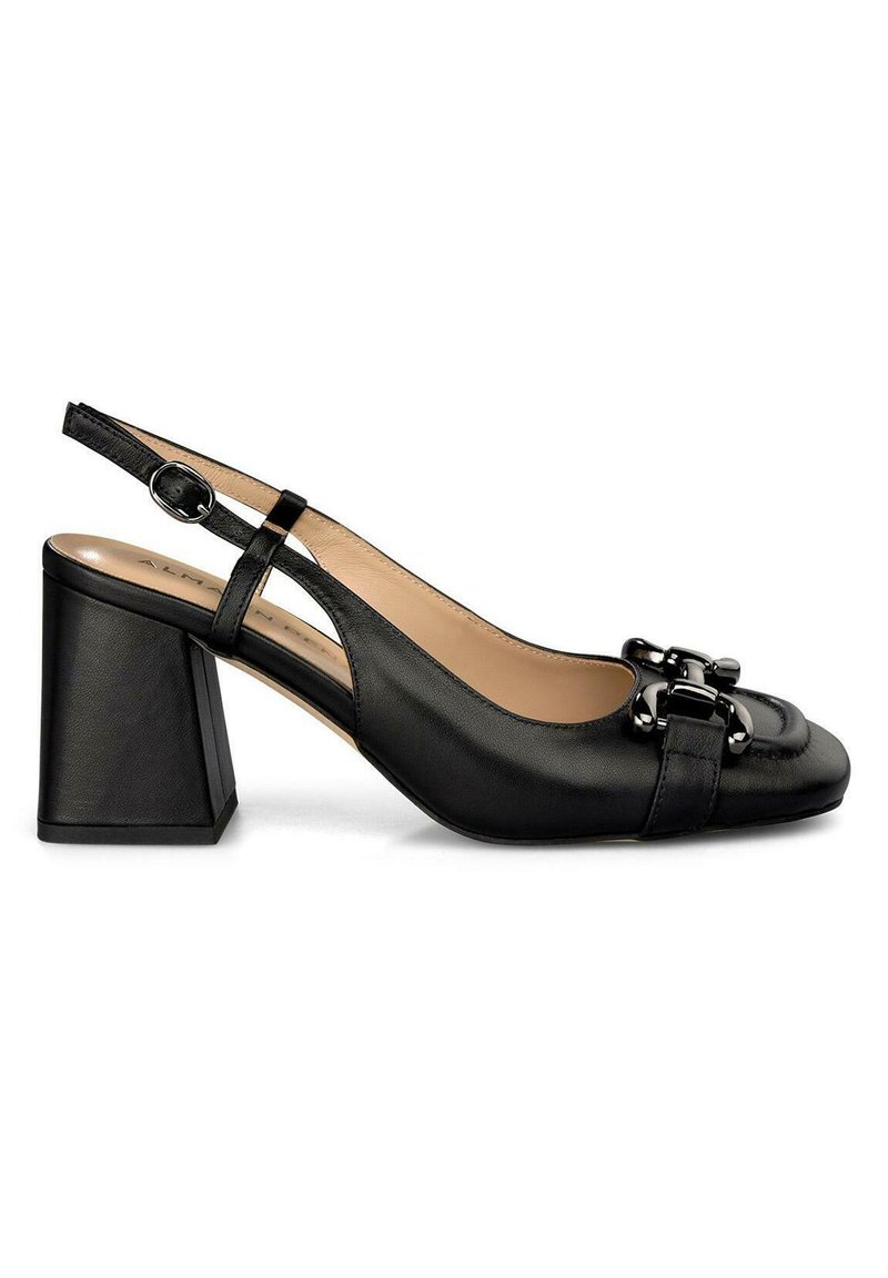 Zapato de tacón bajo de cuero negro con punta cuadrada, tacón rectangular y detalle decorativo de hebilla negra en la correa delantera.