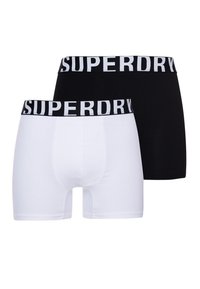 Bóxer en blanco y negro con una cinturilla elástica que presenta el logo "SUPERDRY". Fabricados con un tejido suave que muestra una textura lisa.