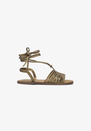 Flat sandals met een gevlochten ontwerp in metallic goud. Heeft enkelbandjes en gestreepte details op de voetbed. De zool lijkt lichtgewicht.
