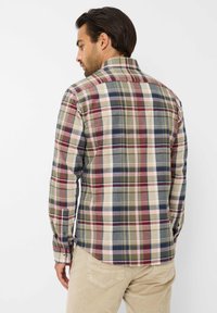 Heren geruite shirt in een meerkleurig ruitpatroon met groen, rood, blauw en beige. Lange mouwen en kraag, met knoopmanchetten.