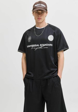Black short-sleeve jersey with horizontal stripes, featuring white text "UNIVERSAL STANDARD" and logos on the chest. Smooth synthetic fabric.