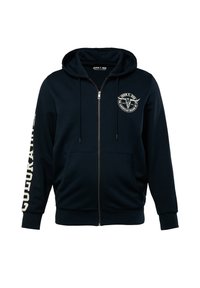 Sweat à capuche zippé bleu marine en tissu doux, avec un patch logo sur le devant, des poches kangourou et des accents de texte blanc sur les manches.