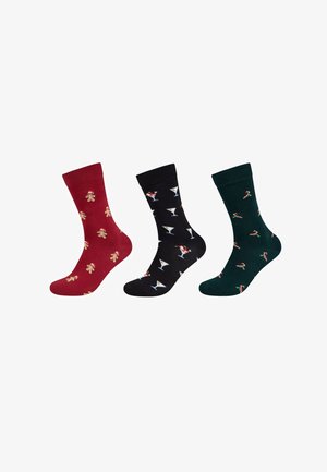 Trois paires de chaussettes : rouges avec des bonhommes en pain d'épice, noires avec des verres à martini, et vertes avec des cannes en sucre. Toutes sont en coton, de longueur mi-mollet.