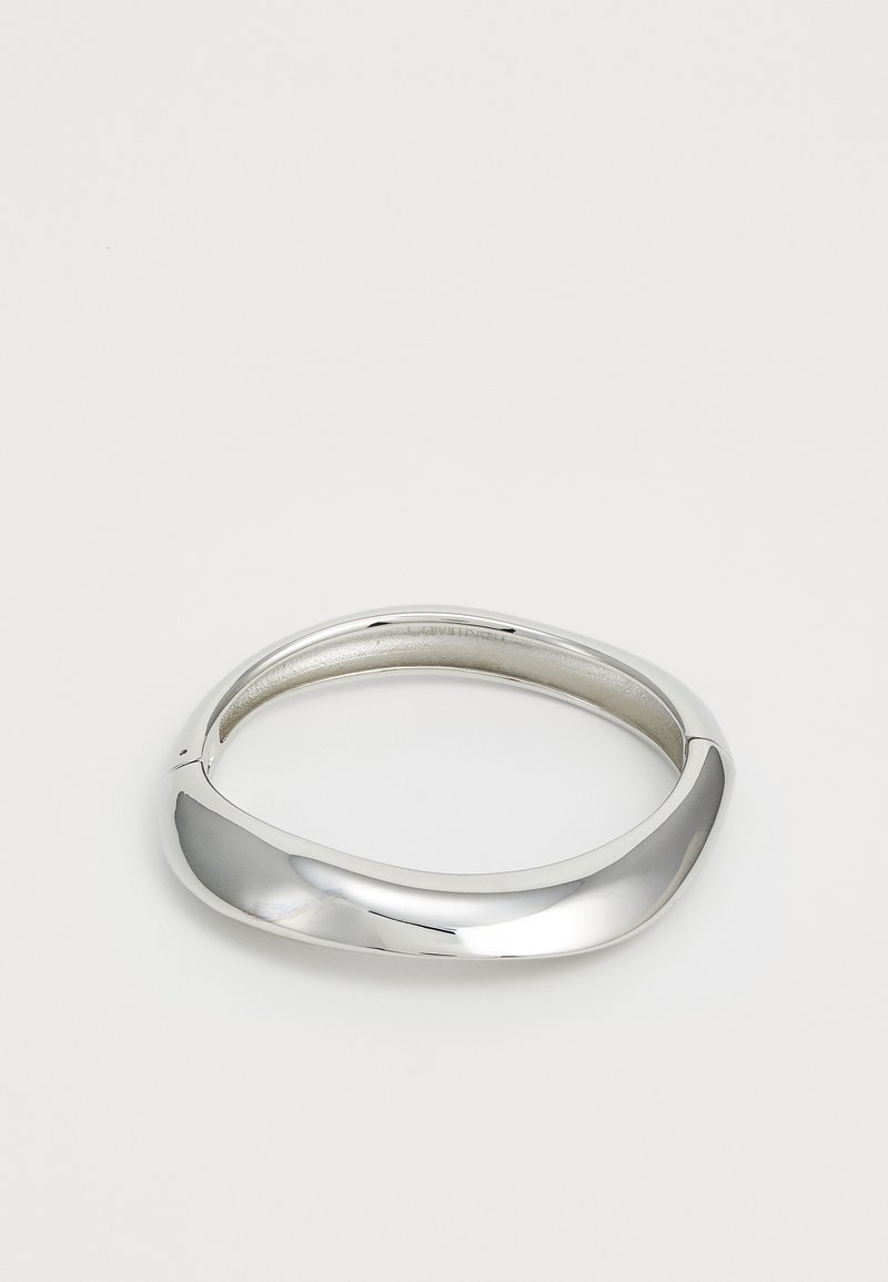 Silvermetallarmband med en slät, böjd design. Polerad yta och rundade kanter skapar ett enhetligt utseende.