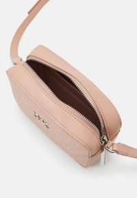 Borsa a tracolla in ecopelle rosa con chiusura a zip, caratterizzata da un motivo in rilievo e accessori in metallo argentato, inclusa un'accessorio con logo.