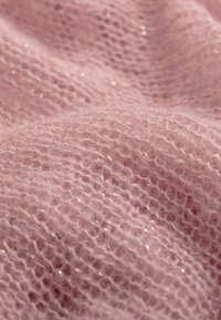 Jasnoróżowa dzianina o miękkiej, przewiewnej teksturze; zawiera subtelne metaliczne złote nitki wplecione w materiał.