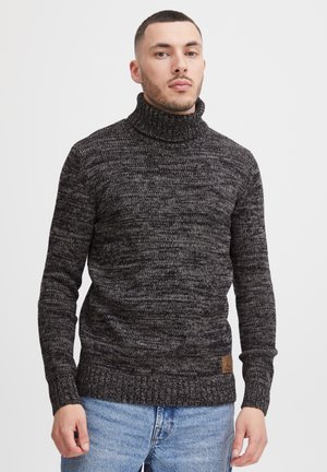 Suéter de cuello alto de punto en gris oscuro y negro con un patrón texturizado, puños y dobladillo acanalados. Presenta un parche de cuero con la marca.