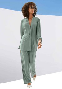 Light green loungewear set featuring a collared long-sleeve top with a button placket and matching loose pants. Smooth fabric texture, elegant cut.