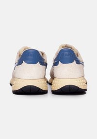 Sneakers beige con una morbida finitura in camoscio, dettagli in pelle blu e suola beige texturizzata con motivi a stella nel tallone.