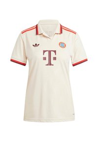 Polo shirt crème avec des accents rouges, arborant un grand logo bordeaux et un petit badge d'équipe. Fabriqué en tissu texturé avec un col et des manches courtes.