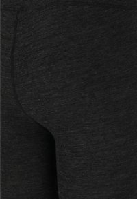 Svarta leggings tillverkade av ett texturerat, lätt material med en jämn yta och subtil lyster, med platta sömmar och utan synliga fickor.