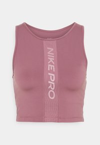 Crop top Nike Pro w miękkim różowym materiale, z prążkowanym designem i pionowym logo 'NIKE PRO' w jaśniejszym różu na środku.