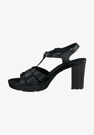 Black heeled sandals with a strappy design, featuring woven leather upper and a textured block heel. Open toe and adjustable ankle strap.