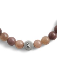 Helmivaltikka, jossa on pyöreitä kiviä hillityissä vaaleanpunaisen ja ruskean sävyissä, keskellä hopeinen metalliosuus, joka esittää eläinhahmoa.