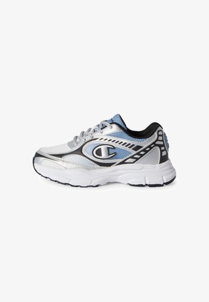Zapatilla deportiva blanca, azul y negra con diseño de cordones y suela blanca gruesa, vista de lado sobre un fondo blanco.