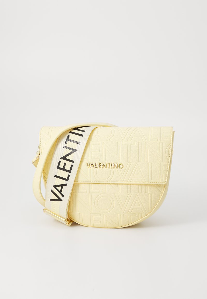 Bolsa crossbody amarela em couro com o logótipo "VALENTINO" em relevo, apresentando uma alça larga branca com texto em preto e detalhes em metal dourado.