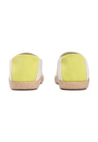 Αθλητικά παπούτσια με λευκό επάνω μέρος από καμβά και έντονες κίτρινες υφασμάτινες λεπτομέρειες, με φυσική σόλα από πλεκτό τσουκνίδα και στρογγυλεμένο πίσω σχέδιο.