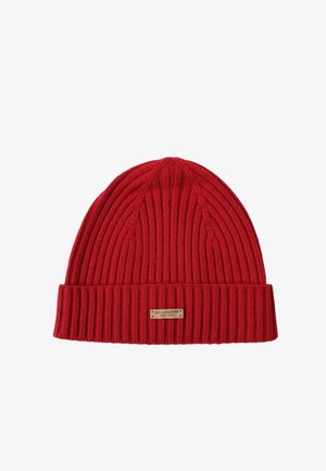 Red ribbed knit beanie with a folded cuff and a decorative label reading "BELLEMERE NEW YORK" in a gold-tone finish.