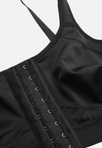 Zwarte sportbeha met verstelbare haak-en-oogsluiting, platte naden en brede banden. Gemaakt van gladde, rekbare stof met een getailleerd ontwerp.