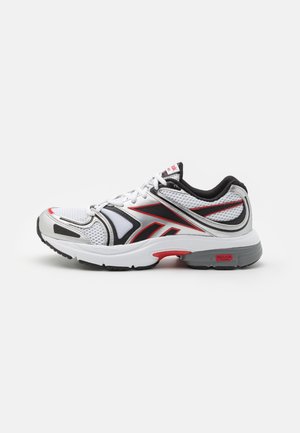 Basket de sport blanche avec des accents noirs, rouges et gris, tige en mesh, semelle amortissante et design à lacets vue de côté.