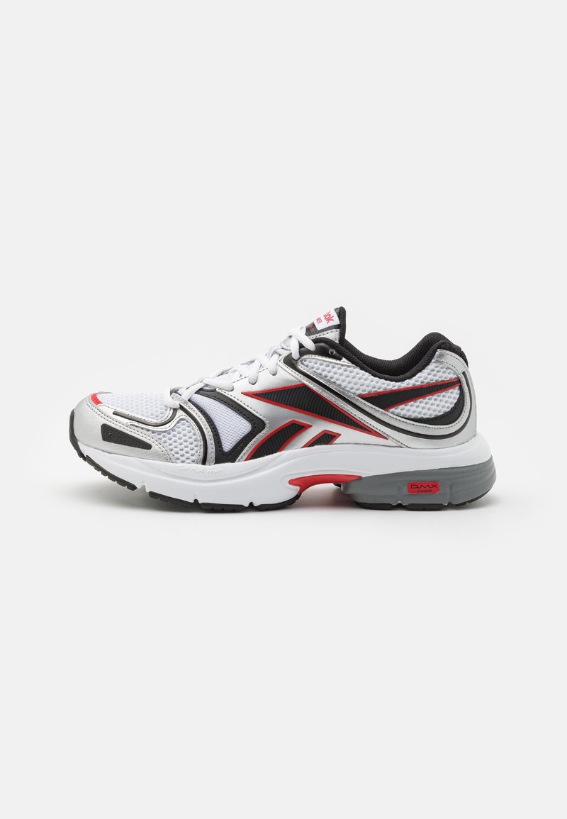 Basket de sport blanche avec des accents noirs, rouges et gris, tige en mesh, semelle amortissante et design à lacets vue de côté.